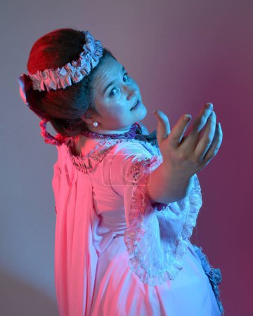 Foto de Retrato de modelo femenina con un vestido rosa opulento, traje de una nobleza barroca francesa histórica, estilo de María Antonieta. Aislado en el fondo del estudio cinemático iluminación colorida - Imagen libre de derechos
