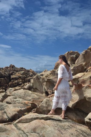 portrait de mannequin femme portant une robe de déesse blanche, paysage naturel dramatique fond de rivage rocheux de l'océan avec des falaises de pierre. castle rock, Busselton, Australie occidentale