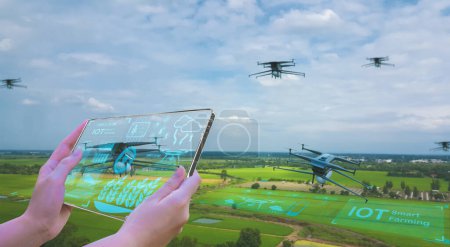Téléchargez les photos : Les agriculteurs utilisent des tablettes intelligentes Contrôlez les drones agricoles, analysez les plantations de riz, le climat, analysez les rendements et les ravageurs, la science agricole, l'intelligence artificielle IOT technologie agricole intelligente - en image libre de droit