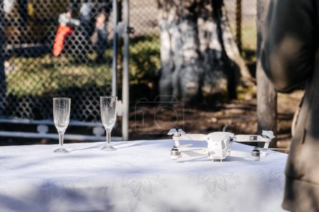 Photo for A fresh chilled glass of ice wine at a wedding, glasses of champagne and a drone on the table. - Royalty Free Image