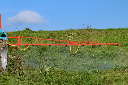 Foto de Tratamiento del campo con herbicidas de plagas y malas hierbas, un tractor en el fondo del cielo y el campo. - Imagen libre de derechos