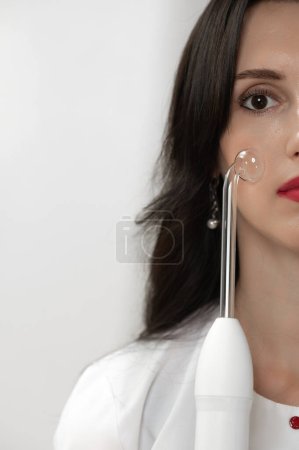 Photo for Skin care with darsonval, darsonval to improve blood circulation, portrait of a girl with darsonval. - Royalty Free Image