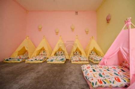 Photo for Baby cots in the kindergarten for naps in the form of tents, bright colors of children's furniture. - Royalty Free Image