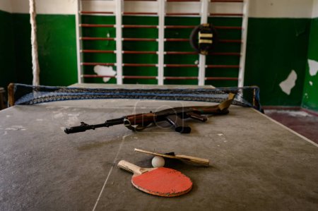 Foto de Una sala de deportes abandonada en la escuela, equipo deportivo destruido por el tiempo, rifle automático en el gimnasio en una escuela abandonada. - Imagen libre de derechos