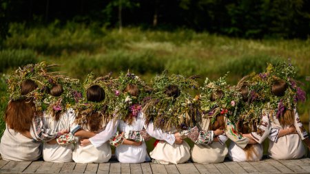 Foto de Niñas en coronas tejidas de varias flores y hierba en un cálido día de verano, Ivan Kupala vacaciones. - Imagen libre de derechos