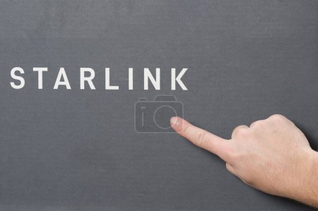 Téléchargez les photos : Ivano-Frankivsk, Ukraine 2 décembre 2023 : Boîte d'antenne Starlink avec logo, pointage de l'index vers l'espace x logo de l'entreprise, antenne de communication par satellite. - en image libre de droit
