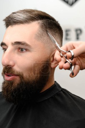 Foto de Corte de pelo y alineación del contorno de la cabeza con tijeras. Corte de pelo corto en la peluquería. - Imagen libre de derechos