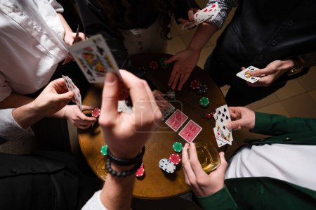 First-person observation of card poker from various close-up angles. A team of young boys and girls play poker.