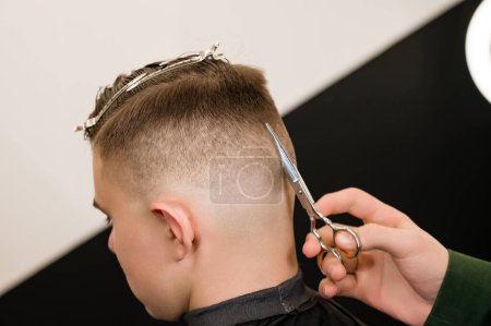 Foto de Corte de pelo y alineación del contorno de la cabeza con tijeras. Corte de pelo corto en la peluquería. - Imagen libre de derechos