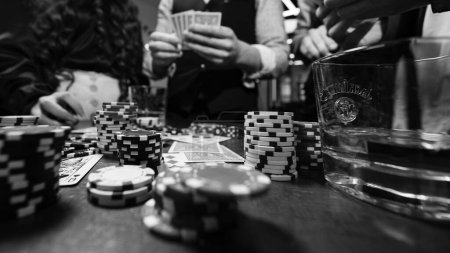 Foto de Ivano-Frankivsk, Ucrania febrero 23, 2024: cinco jóvenes jugando al poker y bebiendo whisky jack daniels, equipo en la barbería. - Imagen libre de derechos