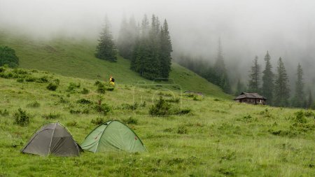 Dos tiendas de campaña en un prado en las montañas, está lloviendo y niebla, descansar en tiendas de campaña.