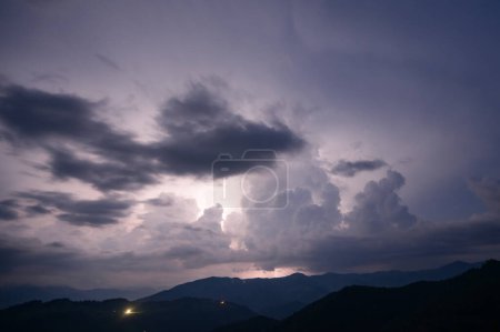 Un orage nocturne avec des éclairs dans les montagnes des Carpates, le village de Dzembronya. Des nuages dramatiques lors d'un orage traversent la lumière de la foudre dans une région montagneuse.