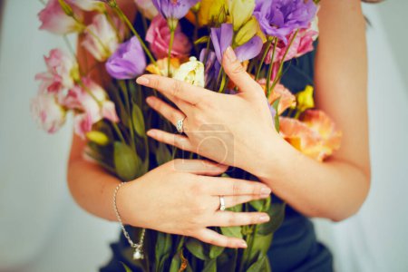 Photo for Women's hands hold flowers in their hands. Girl in jewelry, rings and bracelet. Bouquet for a woman on a holiday on February 14, March 8 - Royalty Free Image