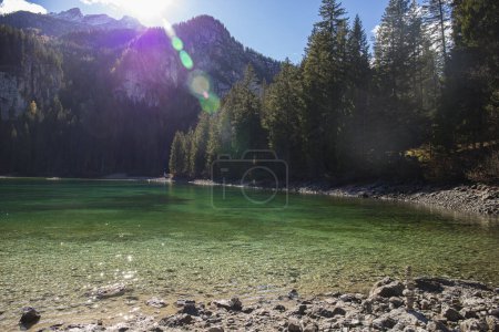 Téléchargez les photos : Les eaux cristallines du lac Tovel, Trentin-Haut-Adige, Italie. Vue d'automne avec éruption solaire. - en image libre de droit