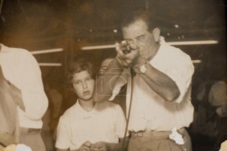 Téléchargez les photos : Père et jeune fille italiens au parc d'attractions de la galerie de tir dans les années 1960. Photographie d'archives noir et blanc. - en image libre de droit