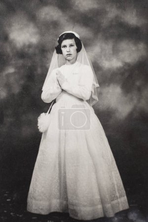 Téléchargez les photos : Une fille italienne le jour de sa première réunion avec la robe blanche traditionnelle en 1962. Photographie d'archives noir et blanc. - en image libre de droit