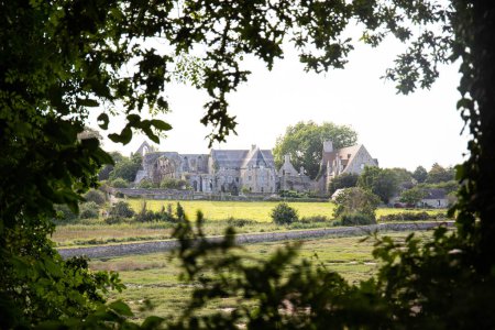 Téléchargez les photos : Abbaye de Beauport, située à Paimpol, Bretagne, France, vue de loin encadrée de feuilles. - en image libre de droit