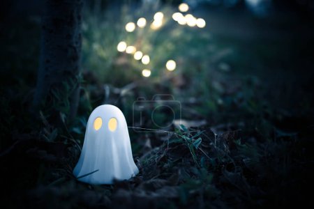 Foto de Figura fantasma o lámpara con ojos iluminados en un entorno al aire libre, espeluznante fondo de halloween. Imagen en tonos fríos, con espacio de copia. - Imagen libre de derechos