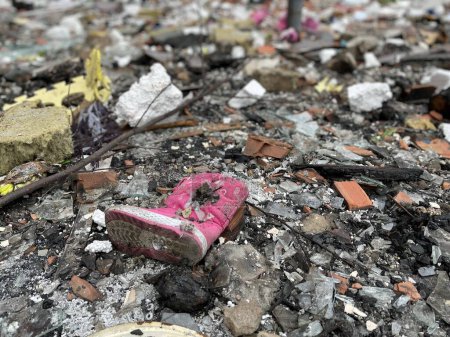Photo for A little girl's shoe near her destroyed house. A little girl's shoe near her destroyed house. Russian aggression against Ukraine. Children's shoes. Destruction. - Royalty Free Image