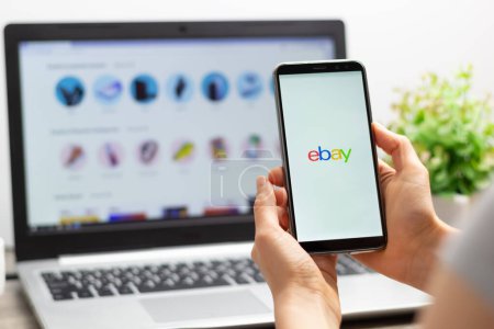 Foto de Kiev, Ucrania - 15 de octubre de 2022: eBay en la pantalla de un smartphone en mano usando tiendas en línea para pagar facturas y comprar bienes. Comercio electrónico. - Imagen libre de derechos