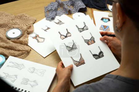 Téléchargez les photos : La créatrice dessine des croquis de sous-vêtements féminins. Lingerie culotte et soutien-gorge sur papier. - en image libre de droit