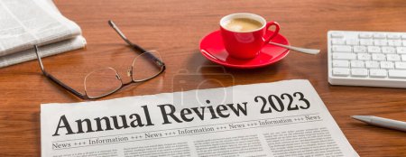 A newspaper on a wooden desk - Annual review 2023