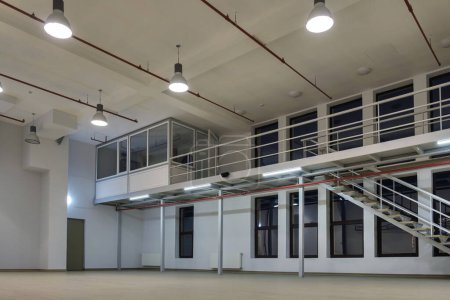 Intérieur d'un grand espace industriel éclairé avec mezzanine