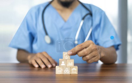 Foto de Mano que arregla el bloque de madera con icono médico de la salud. Concepto de seguro médico. - Imagen libre de derechos