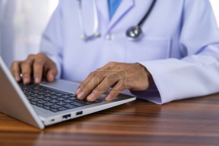 Los médicos utilizan computadoras para registrar los datos del tratamiento en el sistema de almacenamiento de datos del hospital utilizando tecnología moderna.