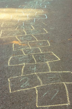 Photo for Chalk drawings on asphalt. Hopscotch game concept. Childhood concept. Painted numbers on the road. Outdoor games. Children activity. Outdoor playground in the city. Colourful hopscotch line. - Royalty Free Image