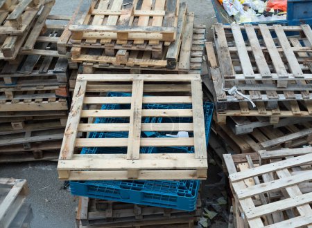 paletas de madera desgastadas, tiradas a la calle, descartadas y sin usar, tumbadas como basura