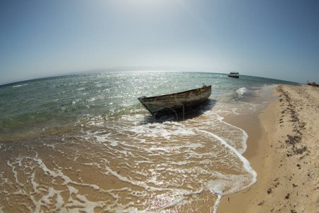 Ein verlassenes Boot steht bei Flut auf dem Wasser des Roten Meeres