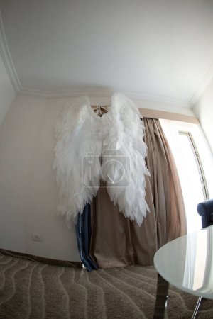 alas artificiales blancas de Isalon, colgando en la pared de la habitación