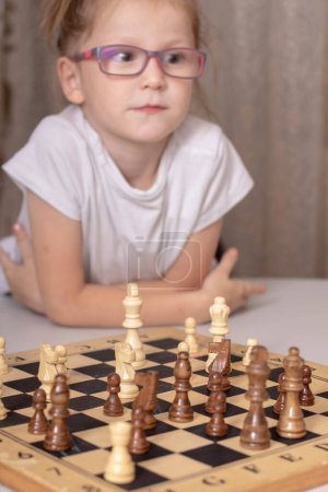 Foto de Linda niña pensando ajedrez en casa - Imagen libre de derechos