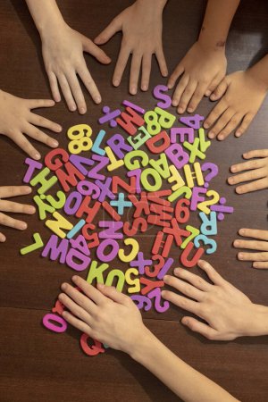 Foto de Niños mostrando coloridos números de plástico. Niños en edad preescolar que aprenden matemáticas en casa. Prepárate para la escuela. vista superior - Imagen libre de derechos