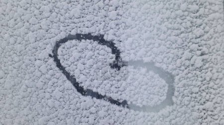 Téléchargez les photos : Coeur dessiné dans la neige, vue de dessus. concept d'amour - en image libre de droit