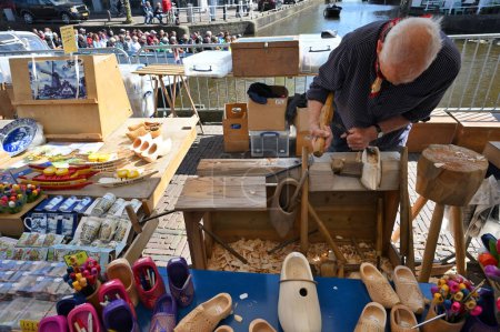 Foto de Alkmaar, Holland - April 22, 2022: Old wooden Dutch shoes - klomps for sale at traditional Cheese Market in Alkmaar, Holland - Imagen libre de derechos