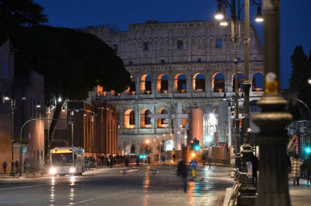 Téléchargez les photos : Rome, Italy - February 16, 2022: View to Colloseum from Via dei Fori Imperiali street at evening in Rome, Italy. The Via dei Fori Imperiali is a road in the centre of the city of Rome - en image libre de droit