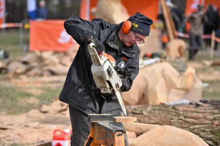 Foto de Kaunas, Lituania - 21 de marzo: Hombre no identificado cortando madera con motosierra Stihl en Kaunas el 21 de marzo de 2024. Stihl es un fabricante alemán de motosierras y otros equipos de mano - Imagen libre de derechos