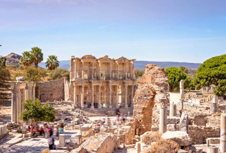 Téléchargez les photos : Celsus ancient Library in Ephesus - Selcuk, Turkey. UNESCO cultural heritage. People are unrecognizable intentionally in motion blur to show the passing of people and remains of the city - en image libre de droit