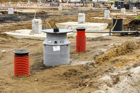 Téléchargez les photos : Joints en béton pour colonnes en acier sur le chantier de construction d'un nouveau bâtiment industriel moderne, installation d'égouts et de puits d'eau de pluie - en image libre de droit