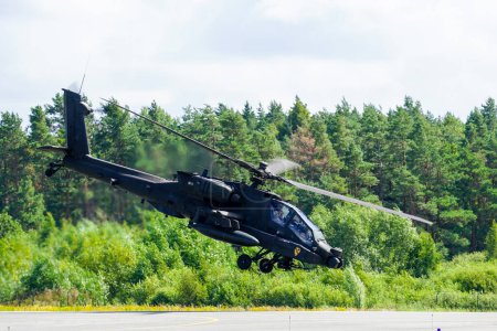 Photo for Liepaja, Latvia - August 7, 2022: An AH-64D Apache attack helicopter takes off from an airport runway in a spectacular manner - Royalty Free Image