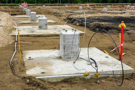 Téléchargez les photos : Rangée de semelles en béton pour colonnes en acier sur le chantier d'un nouveau bâtiment industriel moderne - en image libre de droit