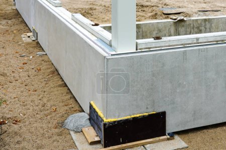 Téléchargez les photos : Le début de la construction de bâtiments avec l'assemblage de blocs de béton de fondation préfabriqués et des colonnes d'acier, des constructions préfabriquées - en image libre de droit