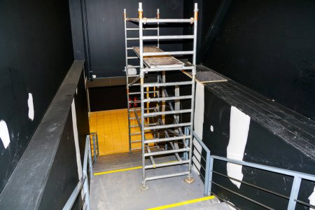 Foto de Cosmetic repair of the stairwell walls of a public building using modern metal tubular multi-level scaffolding - Imagen libre de derechos