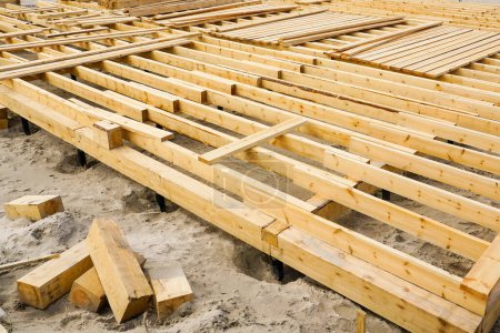 Photo for Construction of a new natural wood plank floor on the Baltic seashore for a seasonal cafe - Royalty Free Image