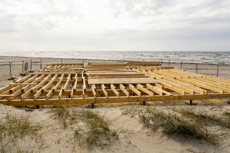 Construction of a new natural wood plank floor on the Baltic seashore for a seasonal cafe