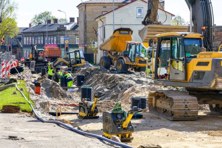Photo for Active street reconstruction site with workers, several excavators, vibratory plate compactors and other machinery - Royalty Free Image