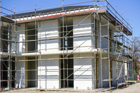 Unfinished construction of a new residential house according to modern technology using prefabricated panels, scaffolding around facade