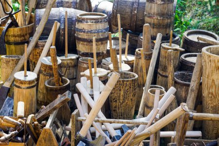 Photo for Ancient traditional old wooden barrels of various sizes with metal hoops, various wooden butter churns, wooden utensils and tools - Royalty Free Image